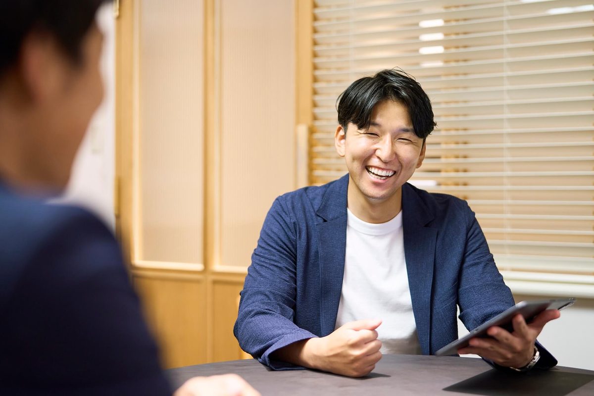 ご相談の様子。担当エージェントがタブレットを手に笑顔で話している